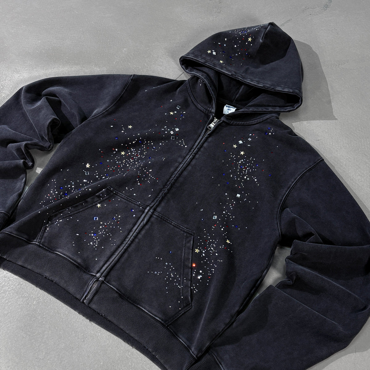 ARTIE MASTER DISTRESSED RHINESTONE ZIP HOODIE; Black; front view in a styled setting