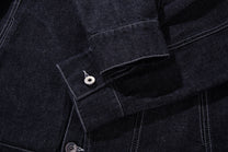 MCCNN ASYMMETRIC CONTRAST STITCH TRUCKER JACKET; Black; garment construction detail