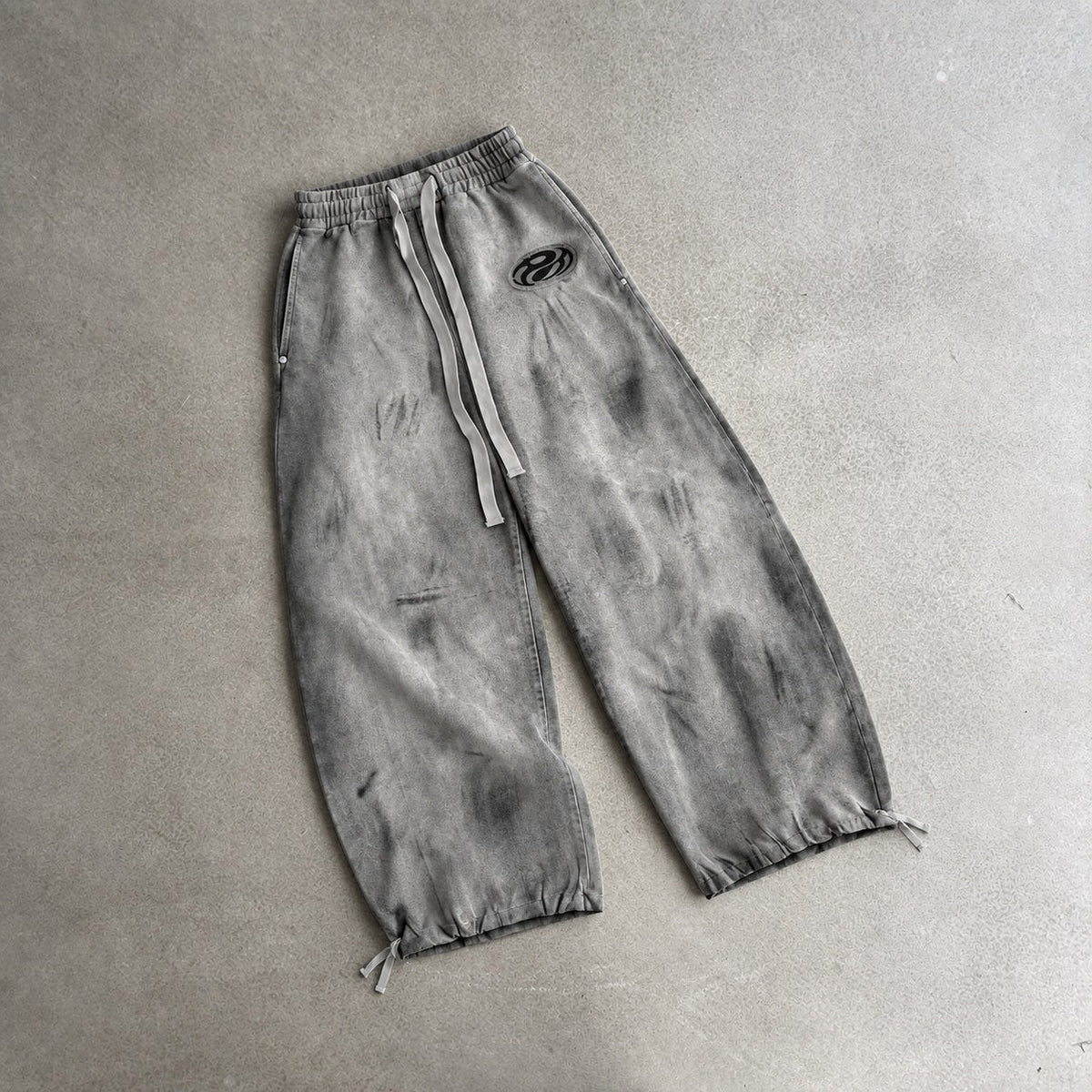 GUO WEAR WASHED CURVED LEG SWEATPANTS; Gray; front view in a styled setting